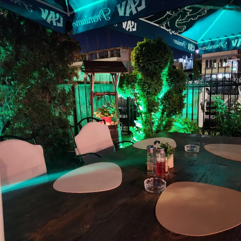 A laid table in the garden under a parasol in the evening